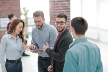 Tablet bilgisayarlı iş ekibi ofiste tartışıyor