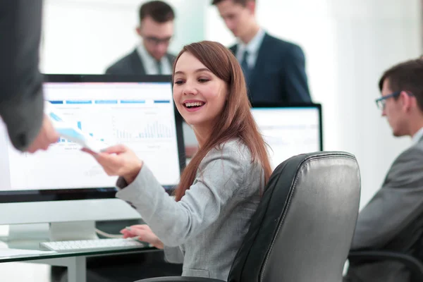 Junge schöne Frau begutachtet Grafiken am Arbeitsplatz — Stockfoto