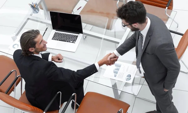 handshake colleagues near the desktop