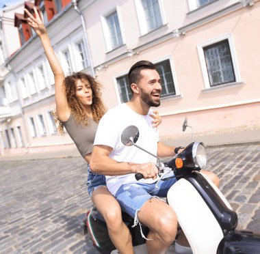 mutlu genç bir çift bir scooter üzerinde eğleniyor