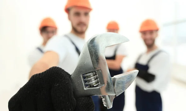 Nahaufnahme. der Schraubenschlüssel in den Händen der Bauarbeiter — Stockfoto