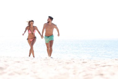 Mutlu aşıklar kumsalda birbirleriyle oynuyorlar..