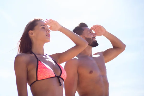 Pareja joven en trajes de baño mirando al mar , — Foto de Stock