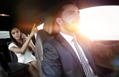 Araba arka koltukta üstünde laptop ile genç iş kadını