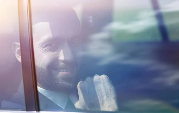 Uomo d'affari di successo guardando fuori dal finestrino di una macchina — Foto Stock