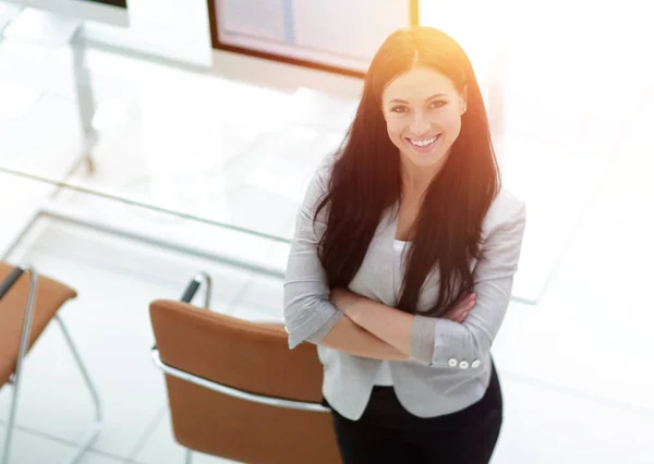 Joven mujer de negocios de pie cerca de un lugar de trabajo moderno . —  Fotos de Stock