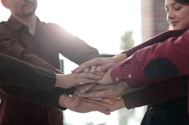 Elleri birbirine kenetlenmiş başarılı bir iş ekibi..