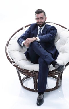 İş adamı rahat bir sandalyede oturuyor.