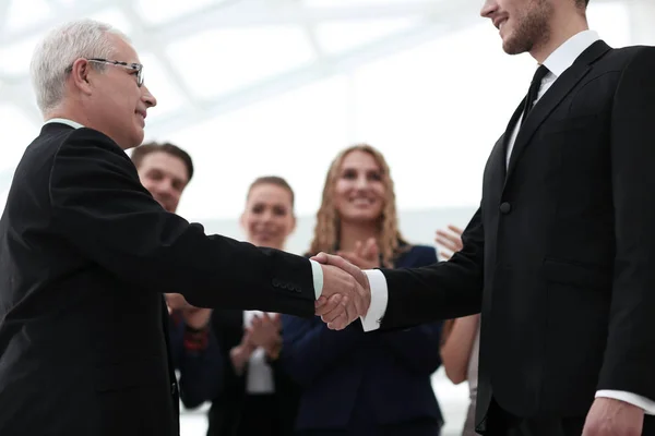 Closeup handshake obchodních partnerů na pozadí zaměstnanců — Stock fotografie