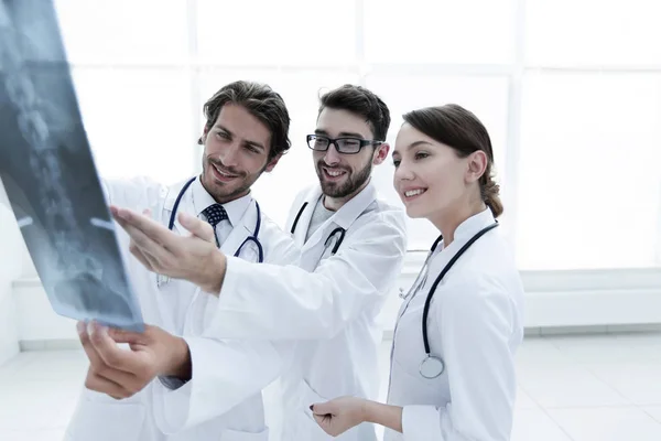 Tres doctores confiados examinan una radiografía —  Fotos de Stock