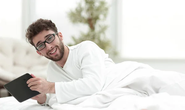 Closeup.sleepy man taking digital tablet — Stock Photo, Image