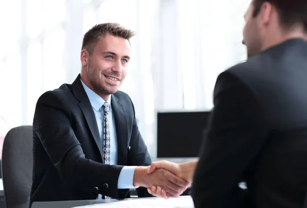 Handshake of business partners sitting at a Desk — Stock Photo, Image