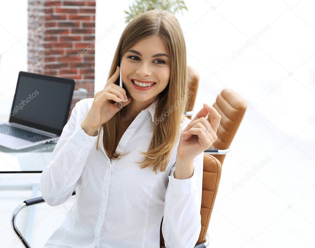 closeup.female assistant talking on mobile phone in office