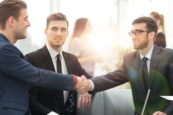 Partners ingår avtal och skakar hand i närvaro av lagmedlemmar — Stockfoto