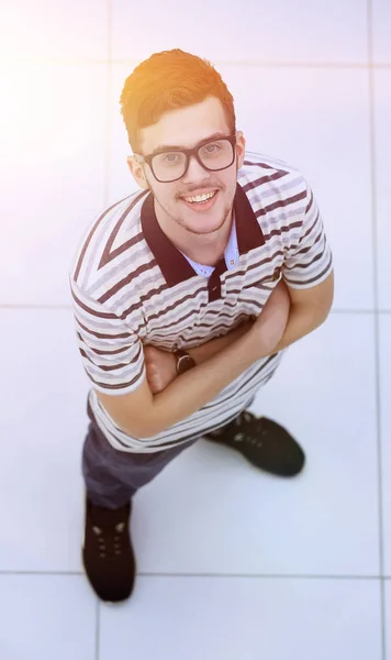 Blick von oben: Erfolgreicher junger Mann mit Brille blickt in Kamera — Stockfoto