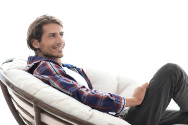 yakın çekim. gülümseyen adam büyük bir rahat sandalyede dinleniyor