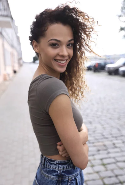 Młoda kobieta z fryzura afro, uśmiechając się w wielkomiejskim — Zdjęcie stockowe