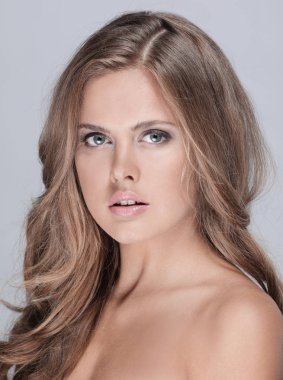 Genç mutlu gülümseyen düşünme kadın, gri backgr portresi