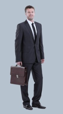 Beyaz arka planda duran yakışıklı genç iş adamı.