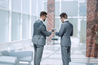 çalışanların dijital tablet kullanma bilgi tartışıyorlar.