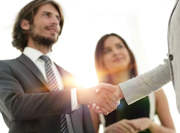 Businesspeople  shaking hands against room with large window loo — Stock Photo, Image