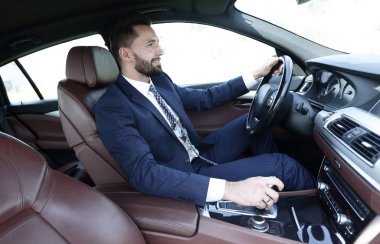 Yan emin işadamı görünümünden bir araba direksiyon başında oturur