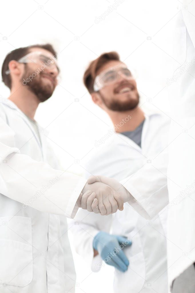 blurred image of a handshake between scientists