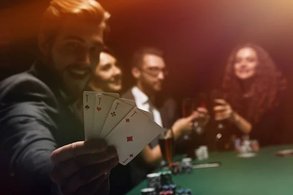 Gambler mannen i casino sitter vid bord med kort och pokermarker — Stockfoto