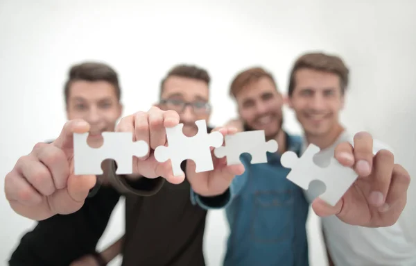Group of young people with puzzle pieces — Stock Photo, Image