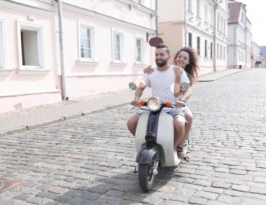mutlu genç bir çift bir scooter üzerinde eğleniyor