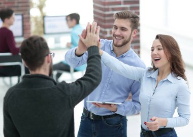 Ofiste tablet kullanan mutlu iş ekibi.
