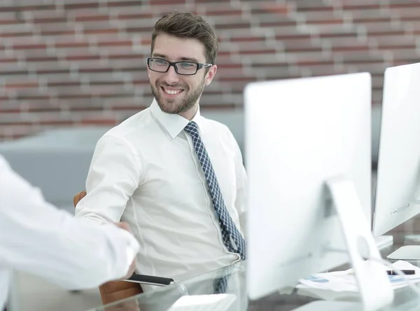 Apretón de manos de los empleados en el escritorio — Foto de Stock