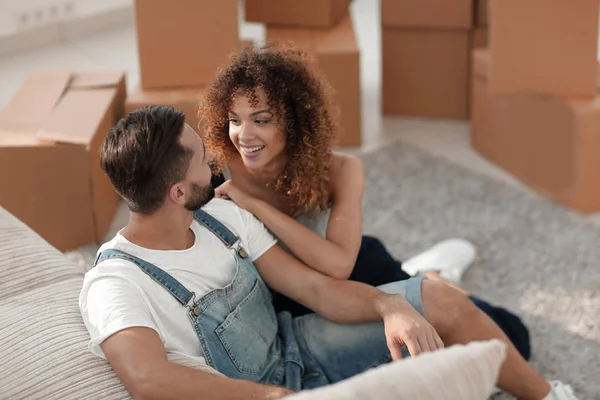 Jovem casal sentado no chão em um novo apartamento — Fotografia de Stock