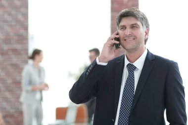 Telefonda konuşurken ciddi iş adamı. Resmi arka plan bulanık için.