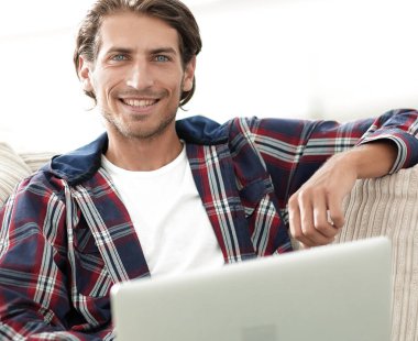 dizüstü bilgisayarda çalışan ve kameraya bakarak başarılı adam. Yukarıdan görüntülemek