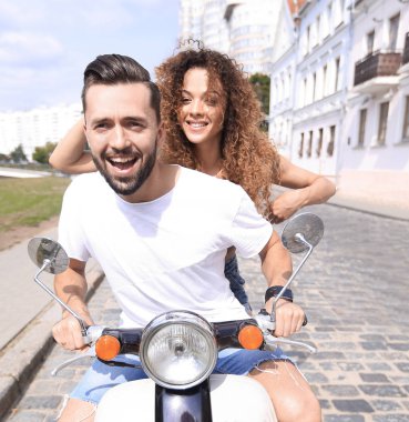 Mutlu çift sürme vintage scooter açık havada.