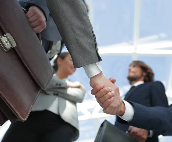 Team kijken naar een zakenpartner handdruk. — Stockfoto