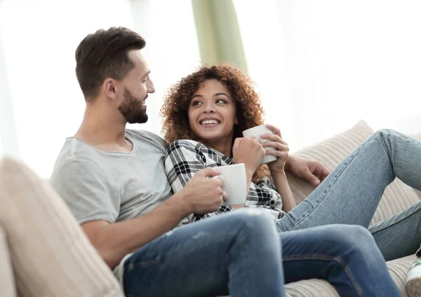 Verliefde paar zittend op een bank in de woonkamer — Stockfoto