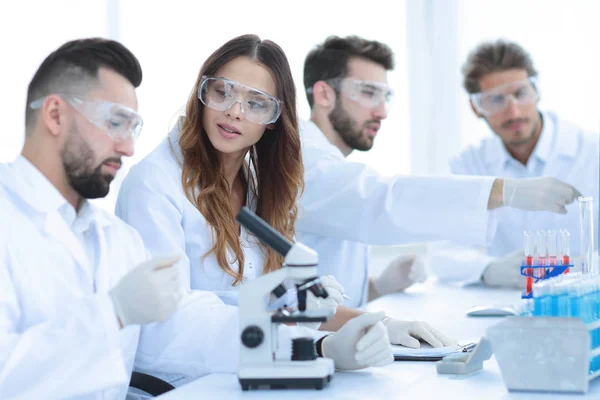 Jóvenes científicos discutiendo los resultados de los experimentos en el laboratorio — Foto de Stock