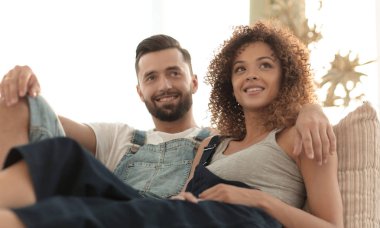 Genç çift kanepede oturan iş elbiseleri