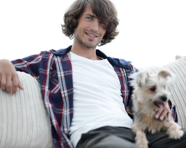 şık adam köpeğiyle kanepede oturan.