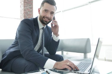 Smartphone üzerinde konuşmak ve metin dizüstü bilgisayarda yazarak işadamı