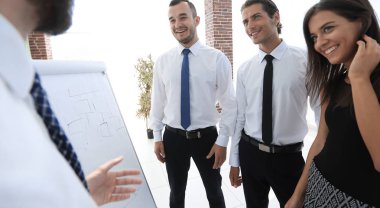 iş takım üzerinde boş bir flipchart işaret eden işadamı.