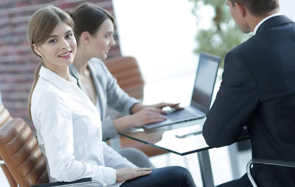 Büroangestellte sitzen hinter einem Schreibtisch. — Stockfoto