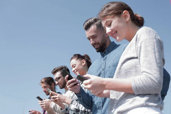 Young people using smartphones to search network — Stock Photo, Image