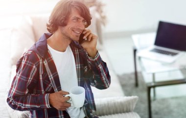 güzel bir fincan adamla bir dizüstü bilgisayar önünde oturur.