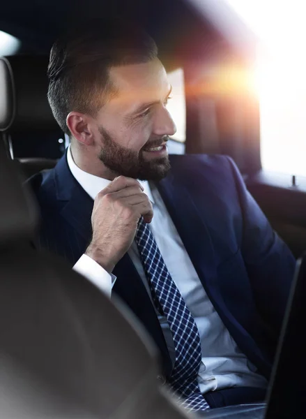 Primer plano de un exitoso hombre de negocios sentado en un cómodo coche — Foto de Stock