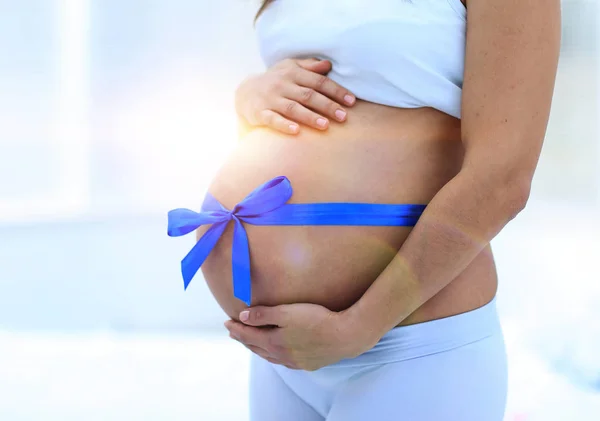 Happy pregnant woman measuring her tummy and waist. — Stock Photo, Image