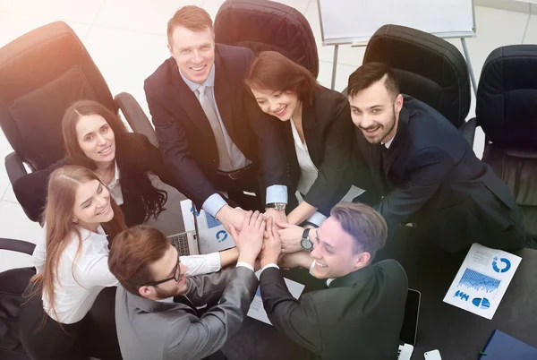 Equipo de negocios con las manos juntas en el escritorio —  Fotos de Stock