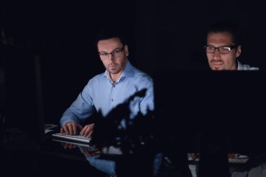 up.Employees iş karanlık ofisindeki bilgisayarlar üzerinde kapatın